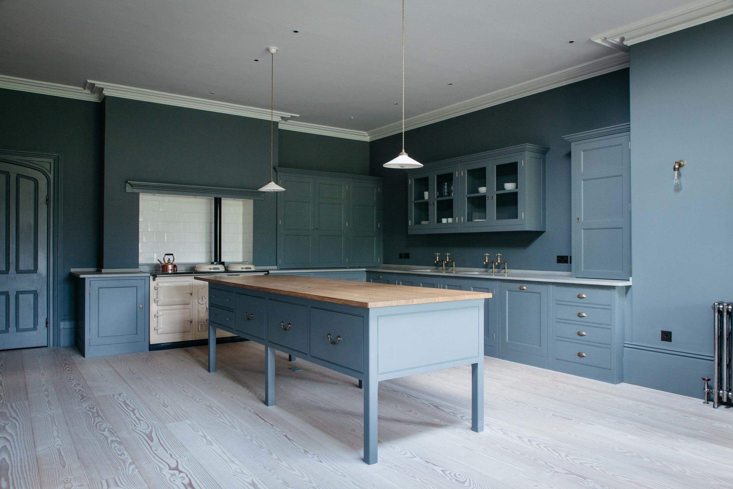  Dark blue kitchen with centre table work surface and Aga