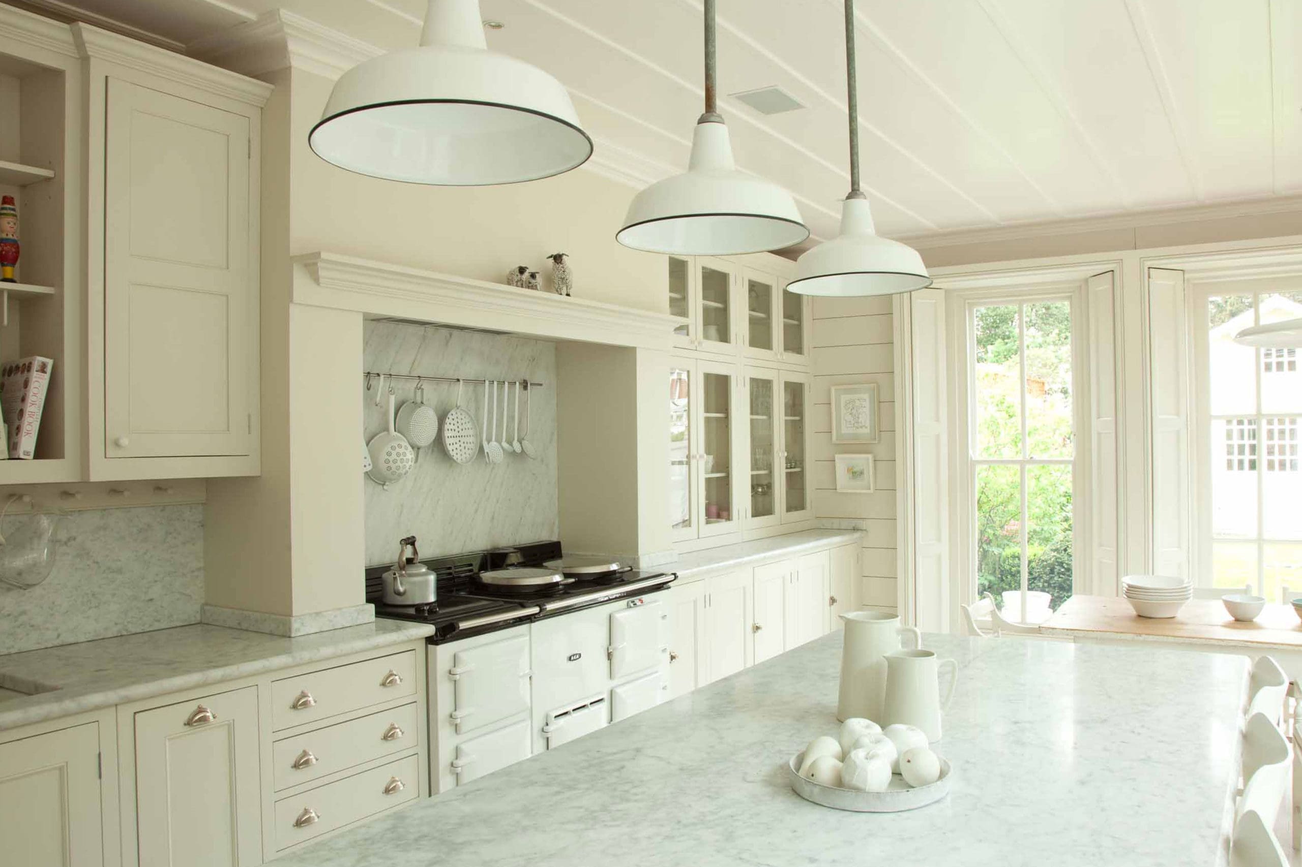  White country kitchen with long dinng table and glass wall cabinets