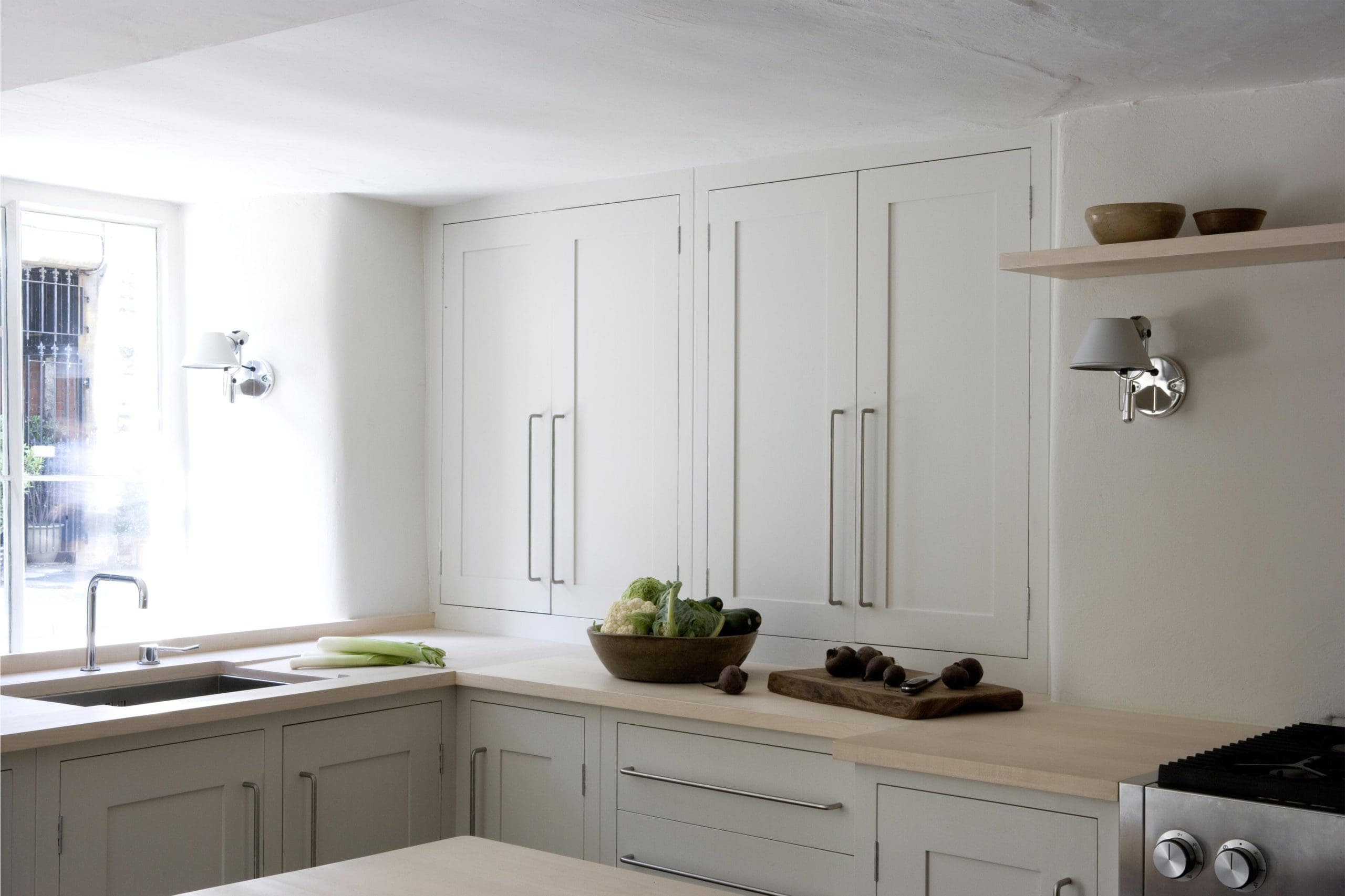  Long, white kitchen cupboards and corner worktop